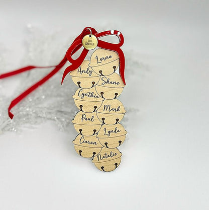 Wooden ornament with names and a red ribbon on a light background