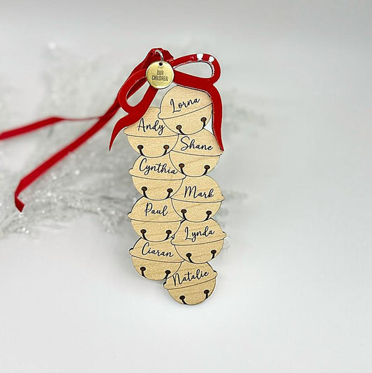 Wooden ornament with names and a red ribbon on a light background