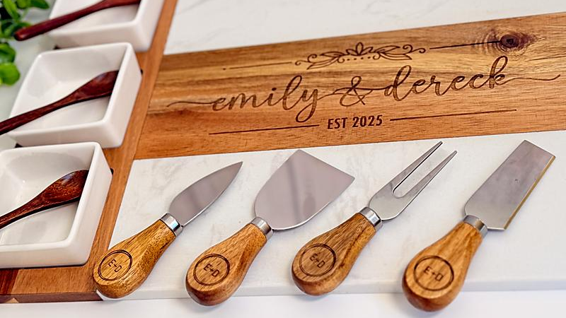 Wooden cheese tools set with engraved names and year on a white surface